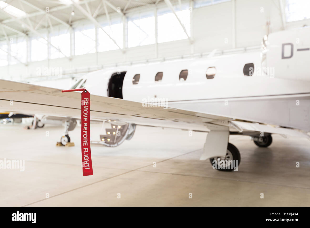 Airplane in Hangar with remove before flight Labels in red Stock Photo ...
