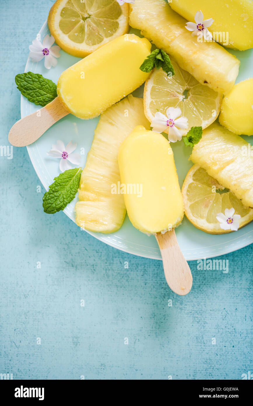 Lemon and pineapple popsicles with fresh fruits and edible flowers