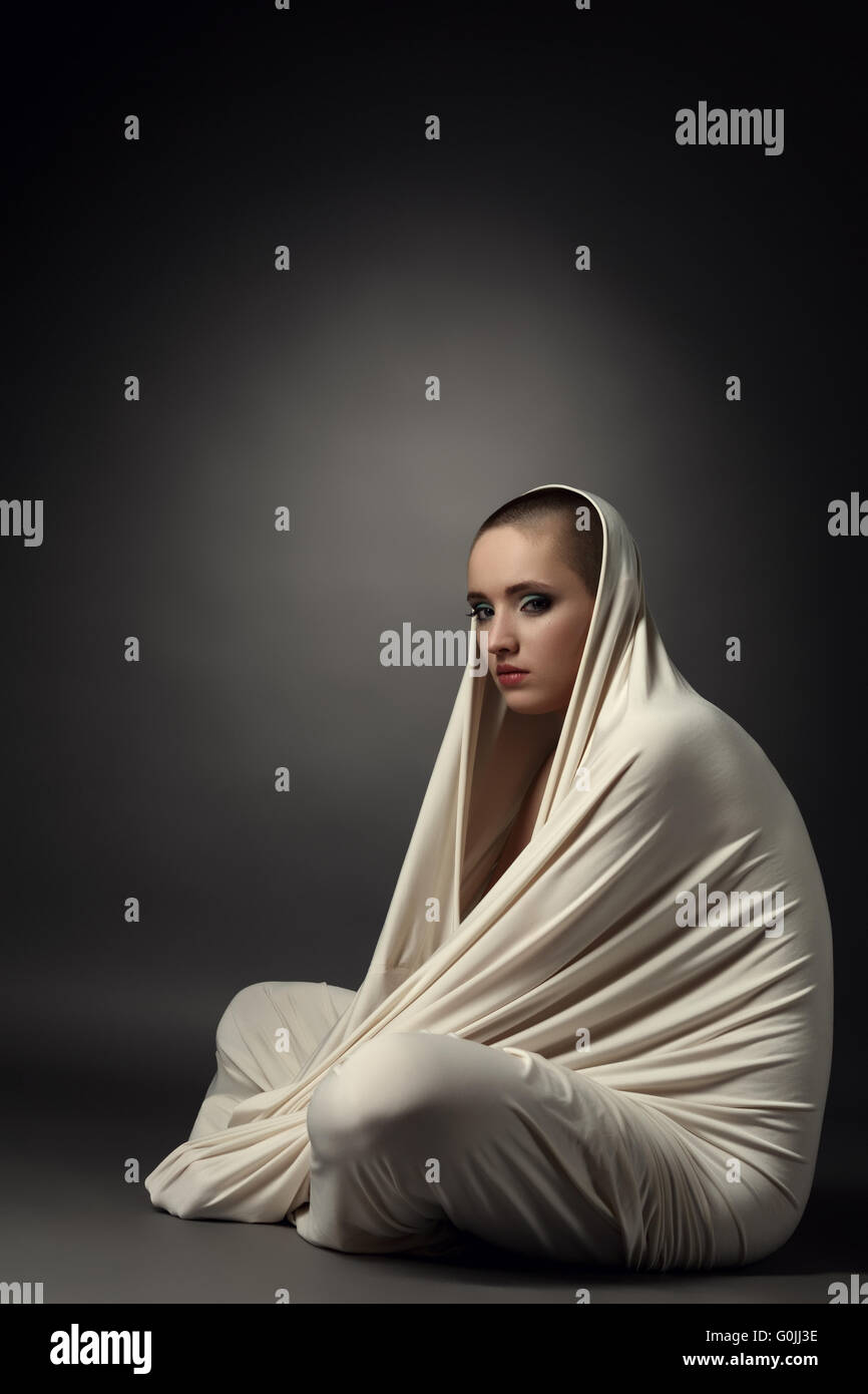 Girl posing as insane patient in straitjacket Stock Photo