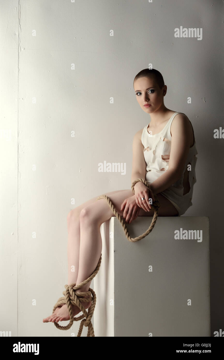 Girl with tied limbs posing as mentally ill person Stock Photo