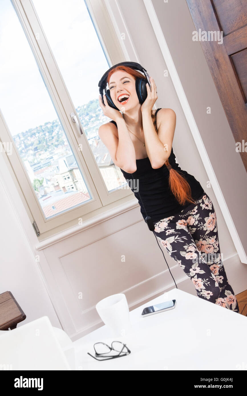 Woman Dancing While Listening Music on Headphone Stock Photo