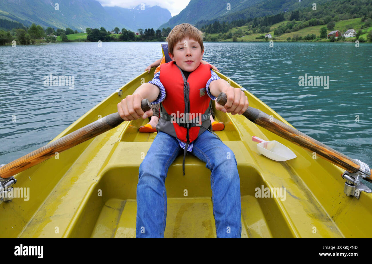 Boy in rowing boat, canoe, Flon Lake, Flon near Olden, Sogn og Fjordane, Norway / Flön, Flön Lake Stock Photo