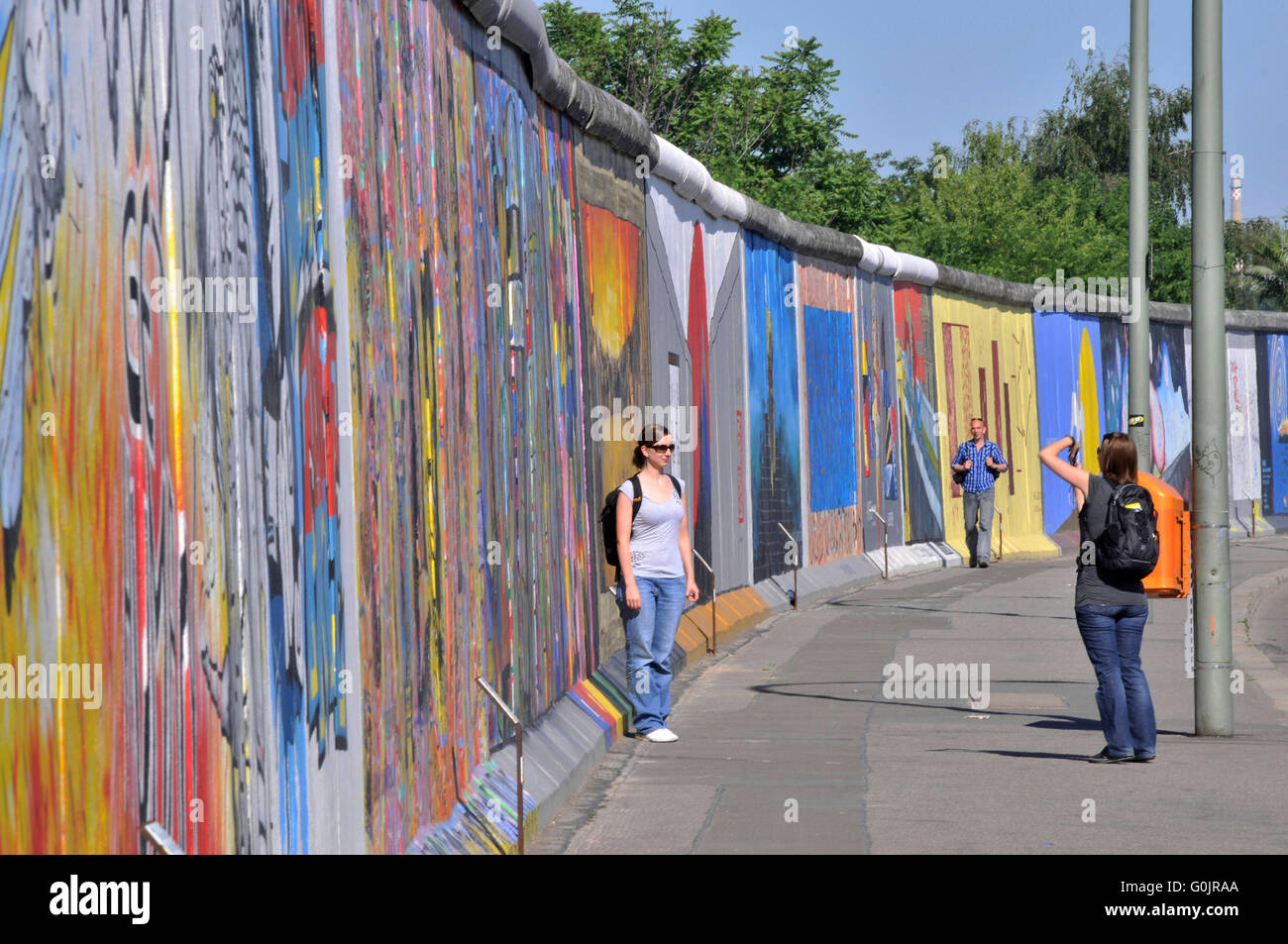 East Side Gallery, mural art, painting, tourists, open-air gallery, Berlin Wall, Friedrichshain, Berlin, Germany / Berliner Mauer Stock Photo