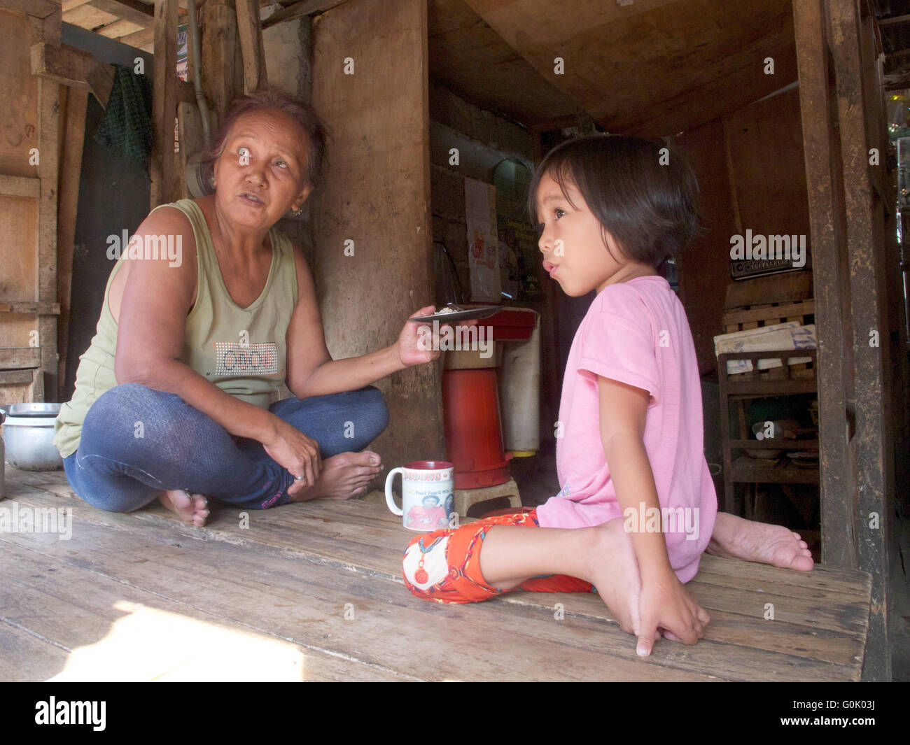 Clarita Alia (L) sits next to her five-year-old granddaughter Cristine in her hut on the market of Davao, the Philippines, 28 April 2016. Four of her sons were murdered. Death squads of Davao city are under suspicion. Mayor Duterte who is leading in the polls for the presidential elections has 'cleaned up' his city, as he says. Photo: CHRISTIAN OELRICH/dpa Stock Photo