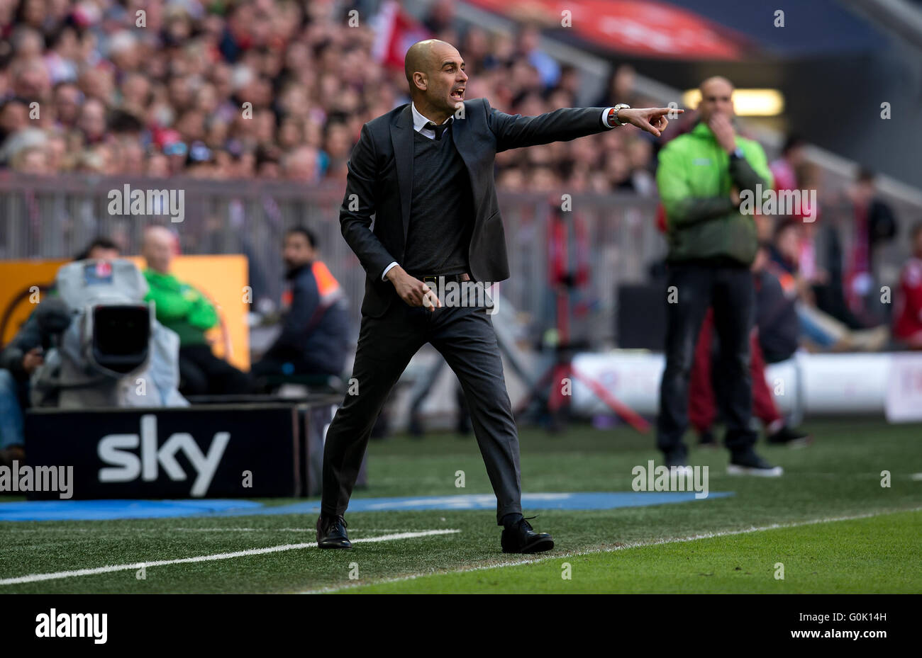 Munich, Germany. 30th Apr, 2016. Munich's head coach Josep Guardiola (L) and his Gladbach counterpart Andre Schubert watch from the sidelines during the German Bundesliga soccer match between Bayern Munich and Borussia Moenchengladbach at the Allianz Arena in Munich, Germany, 30 April 2016. Photo: SVEN HOPPE/dpa/Alamy Live News Stock Photo