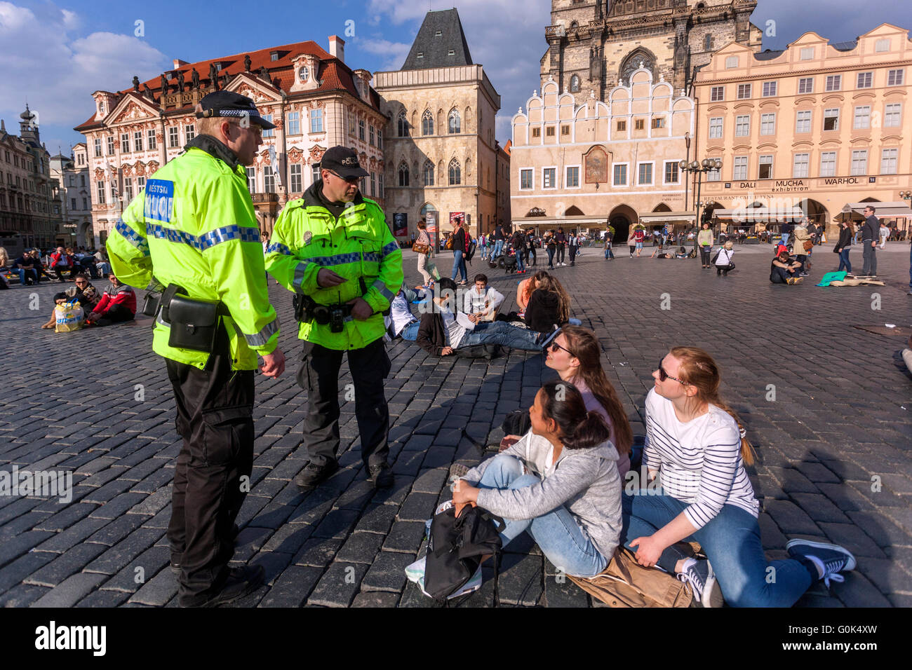 Old Town Square, Prague, Czech Republic, May 2, 2016. For feeding pigeons in a public place a disciplinary fine. Three young girls (pictured) from Poland in the Kiosks bought sausage with mustard and bread. The remaining bread, then threw pigeons. For them municipal police officers fined 300 Czech crowns (around 11 euros) each. In the case of non-payment would be a protocol, and possibly fines could reach up to 5,000 Kc. The policemen were very uncompromising and Girls paid. Stock Photo