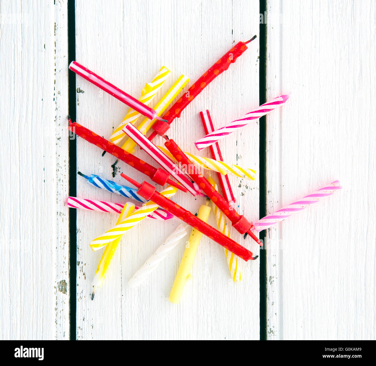 Used Birthday Candles on a retro white wooden background Stock Photo