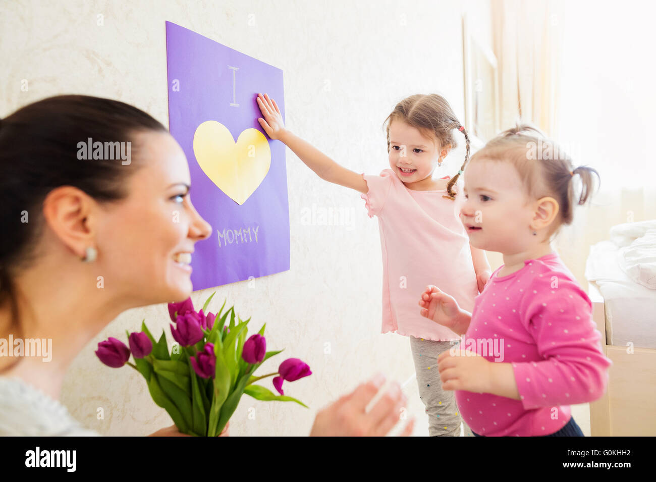 Mothers day, girls giving flowers and card to their mum Stock Photo