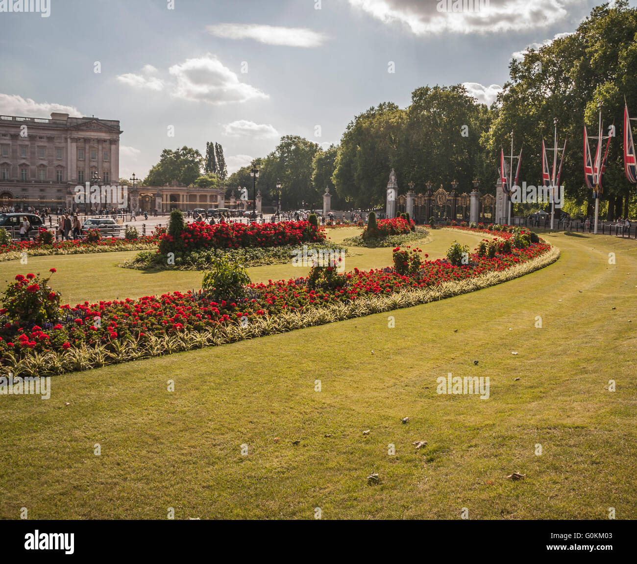 The flowered gardens at the bottom of the Mall outside of Buckingham Palace with the trees and Union Jack flags Stock Photo