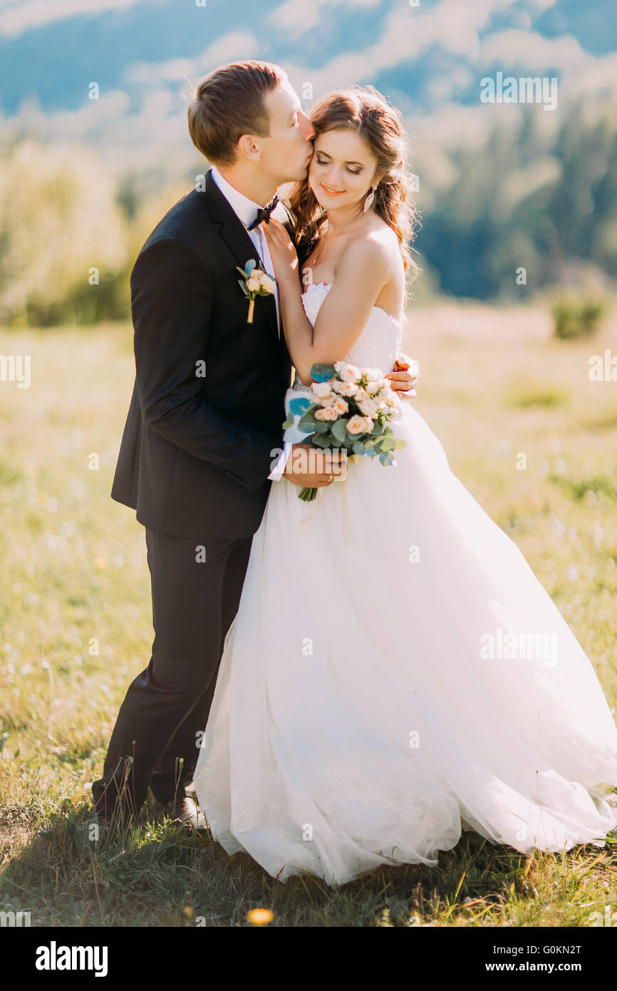 Loving Groom Kissing Brides Forehead On Wedding Walk Stock Photo Alamy