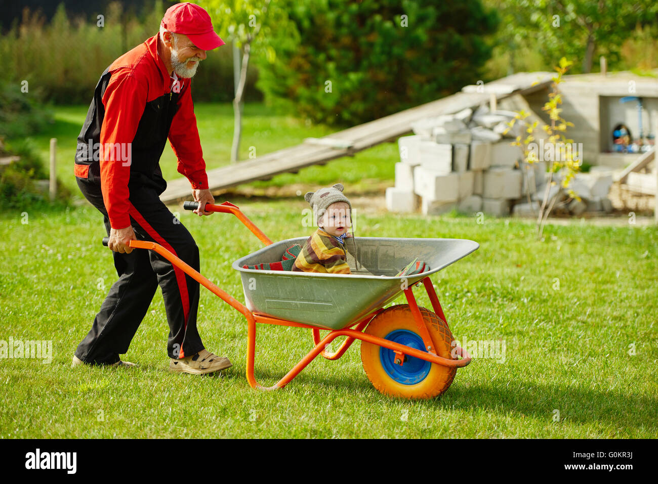 cute little boy sitting in wheelbarrow Stock Photo - Alamy