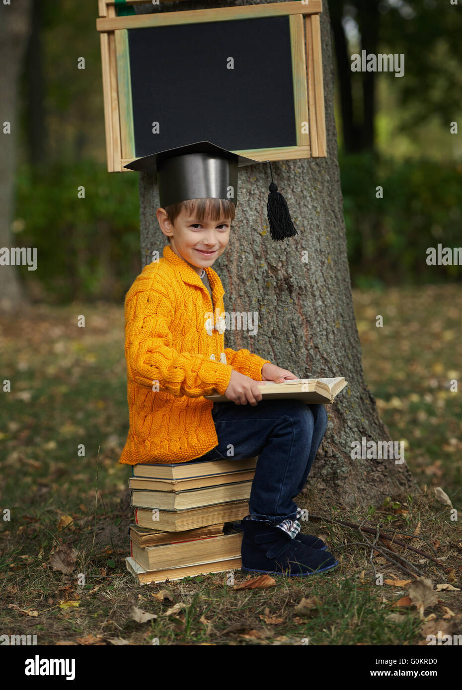 little boy sitting on stack of books Stock Photo - Alamy