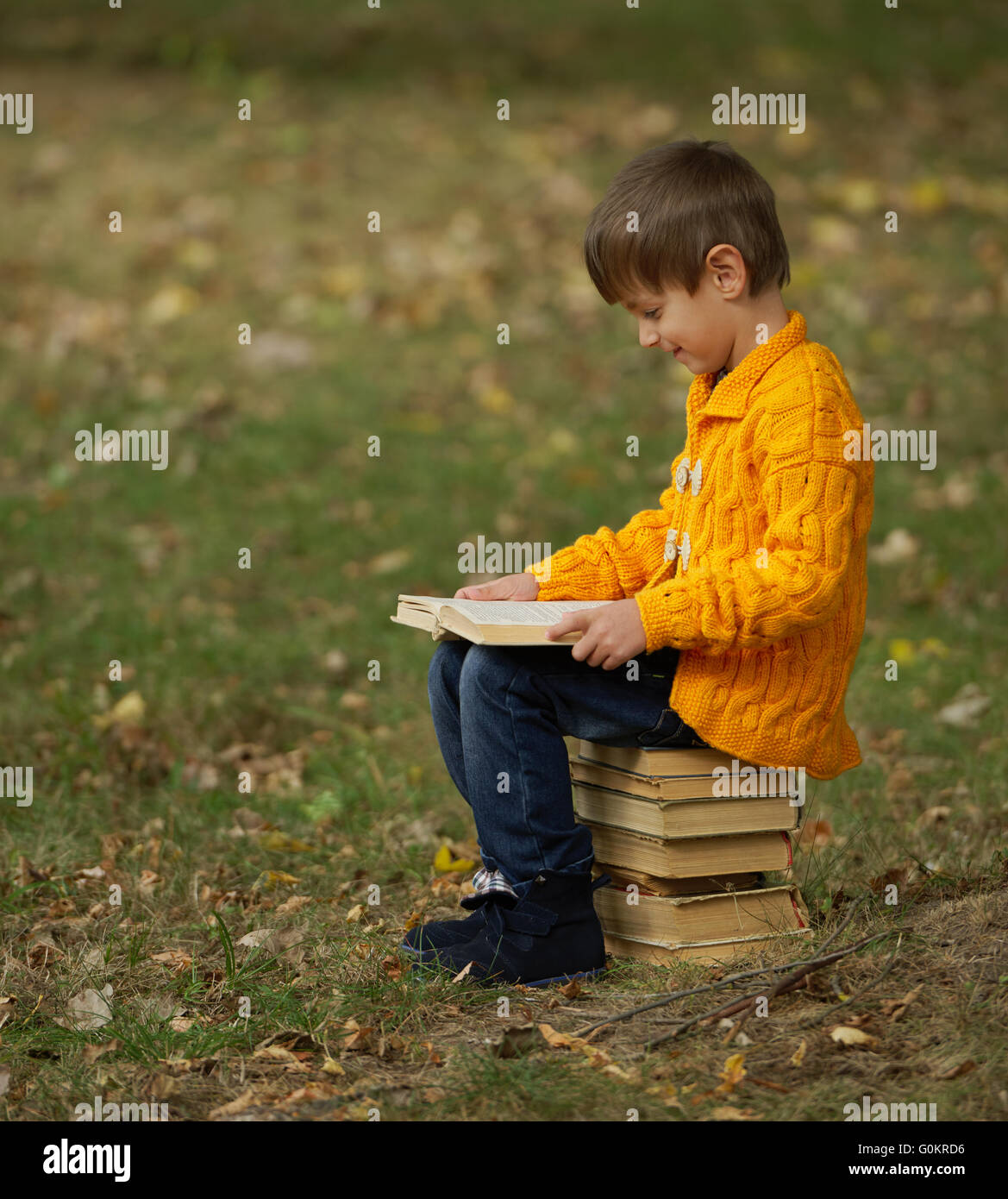 little boy sitting on stack of books Stock Photo - Alamy