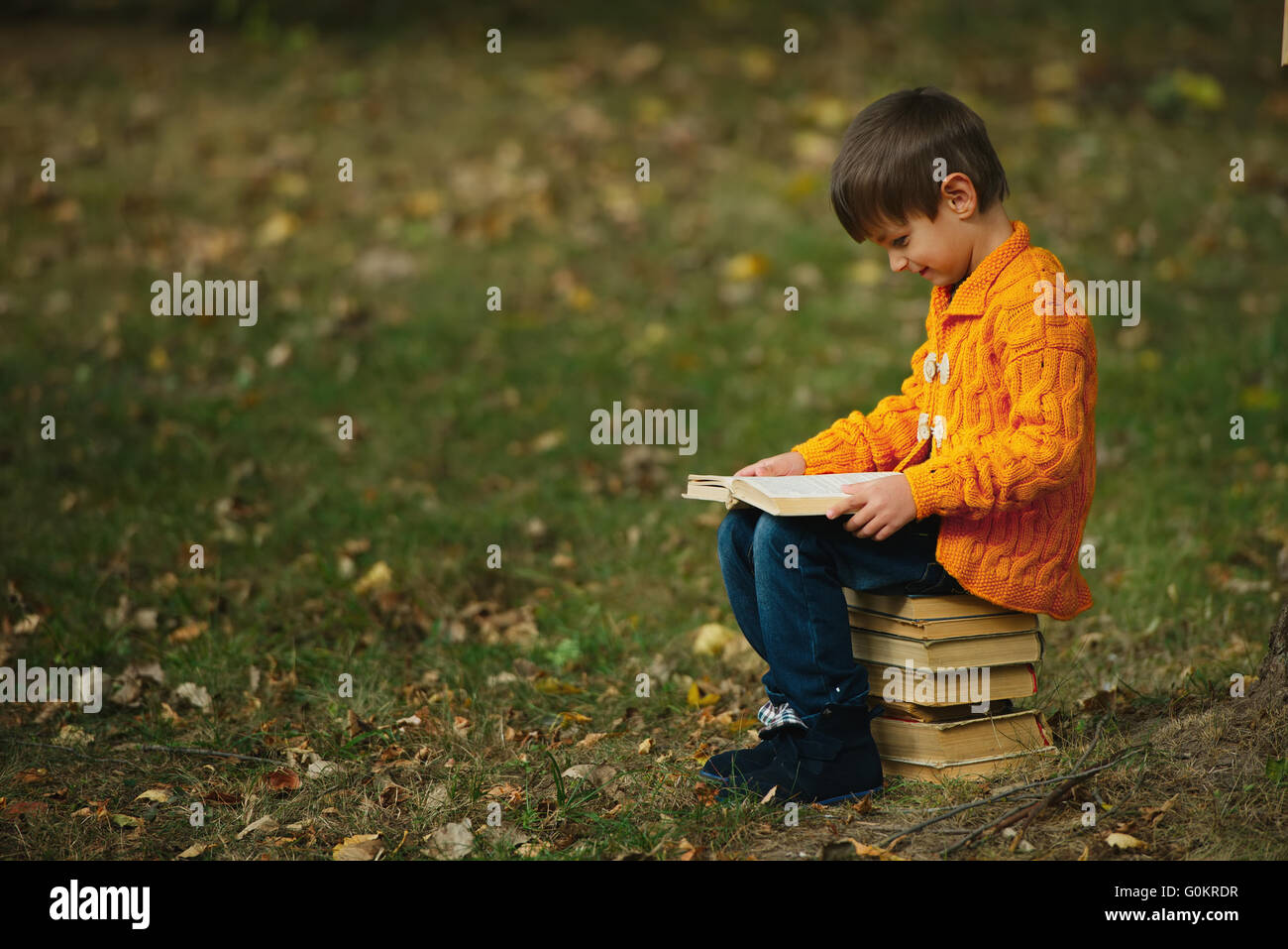 little boy sitting on stack of books Stock Photo - Alamy