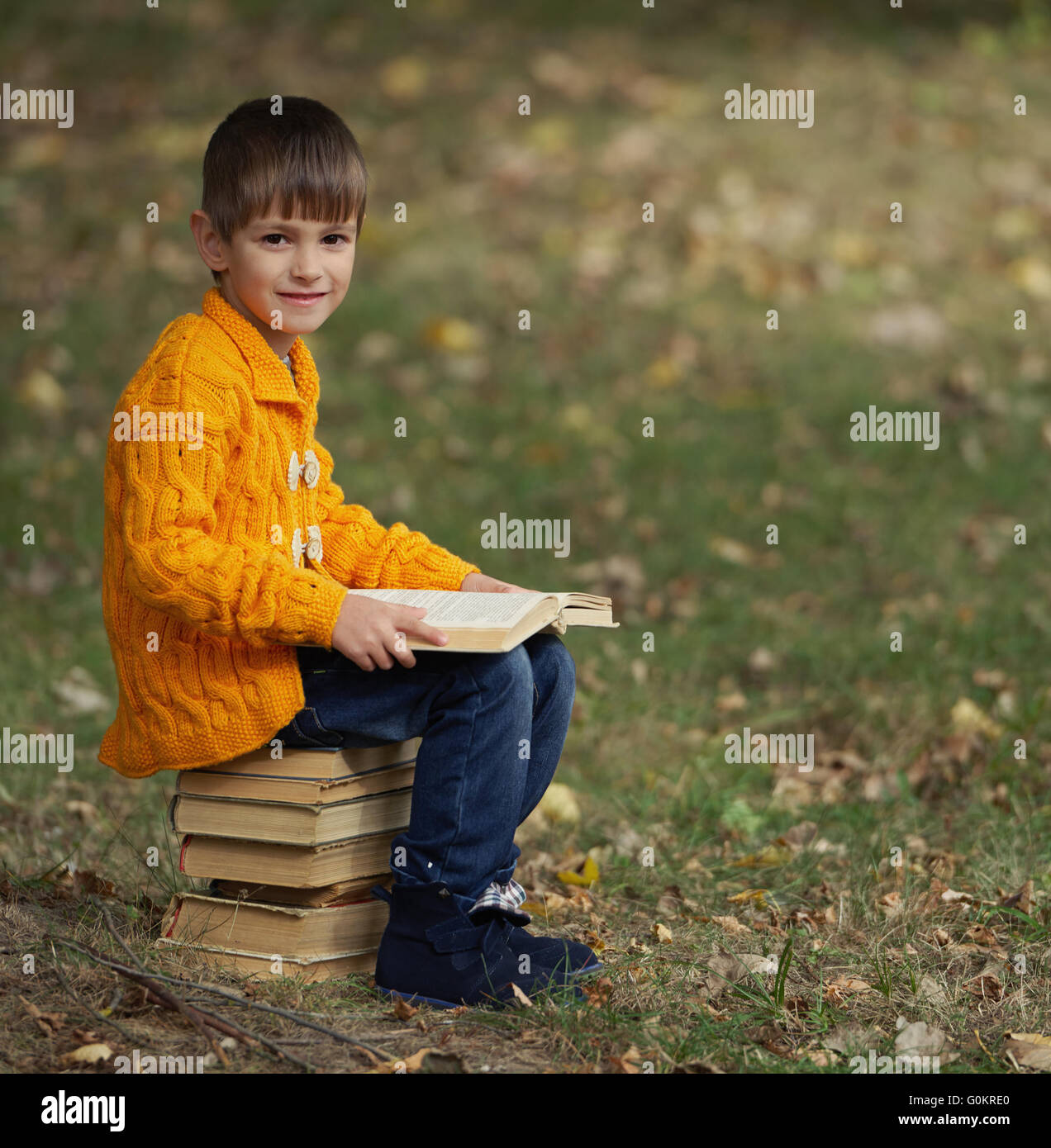 little boy sitting on stack of books Stock Photo - Alamy