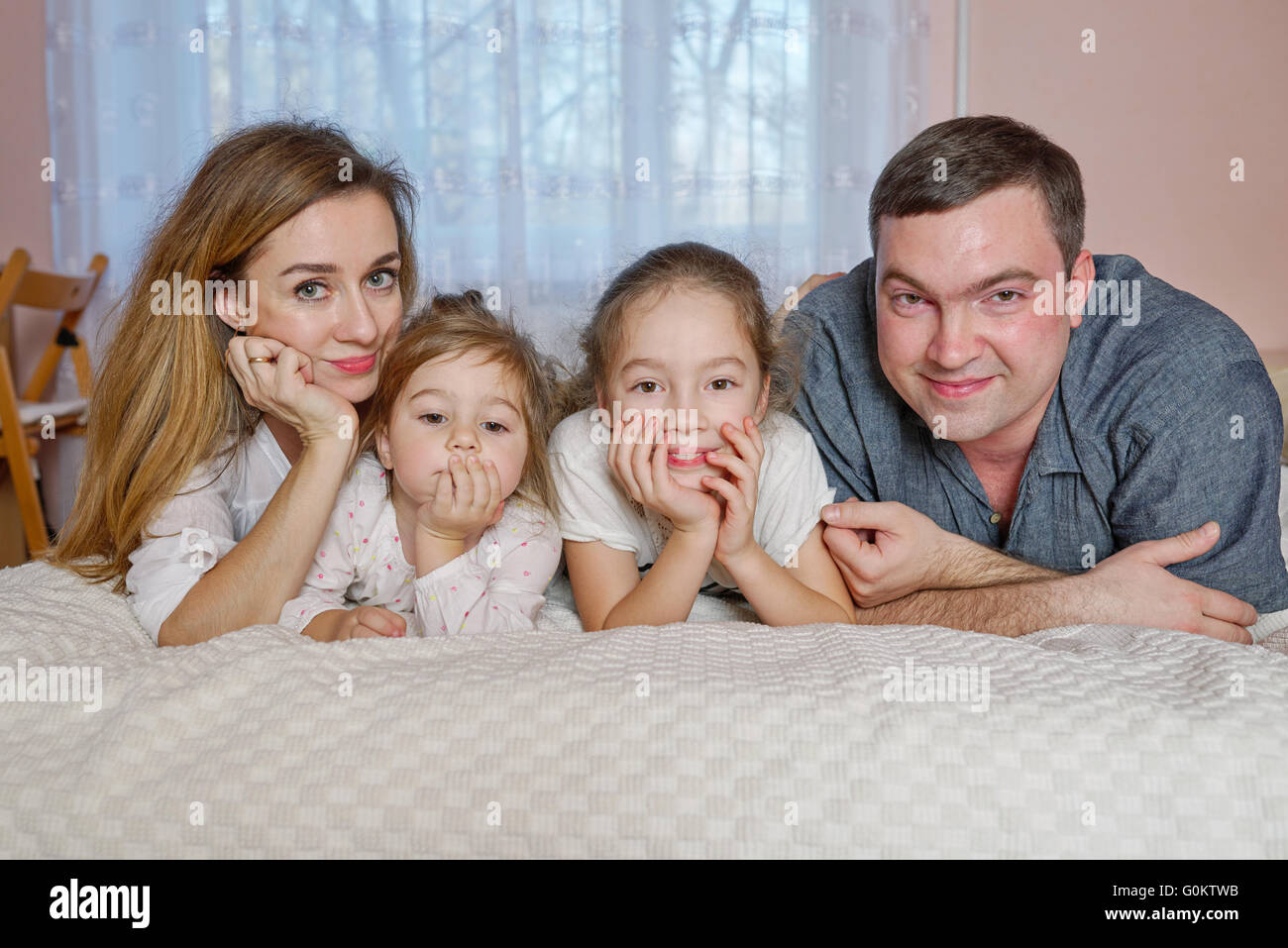 happy young family lying in bed Stock Photo