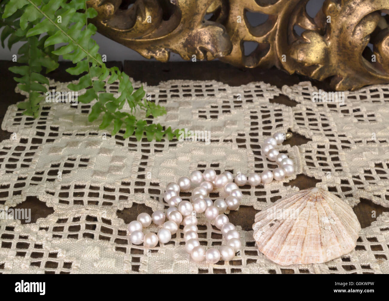 Pearl necklace, shell, embroidered cloth on dressing table Stock Photo