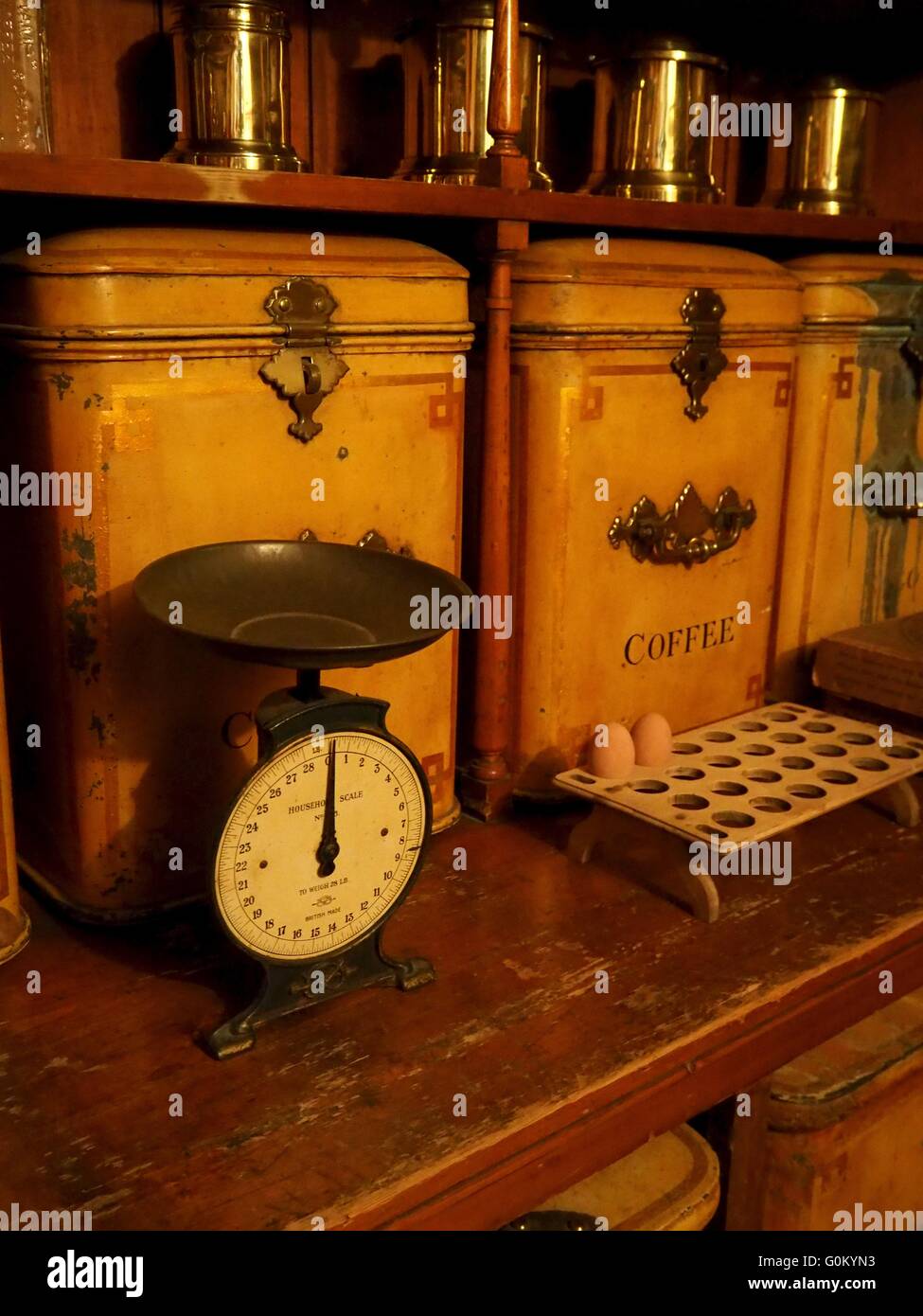 Old pantry with vintage weighing scales, large coffee tin and egg rack Stock Photo