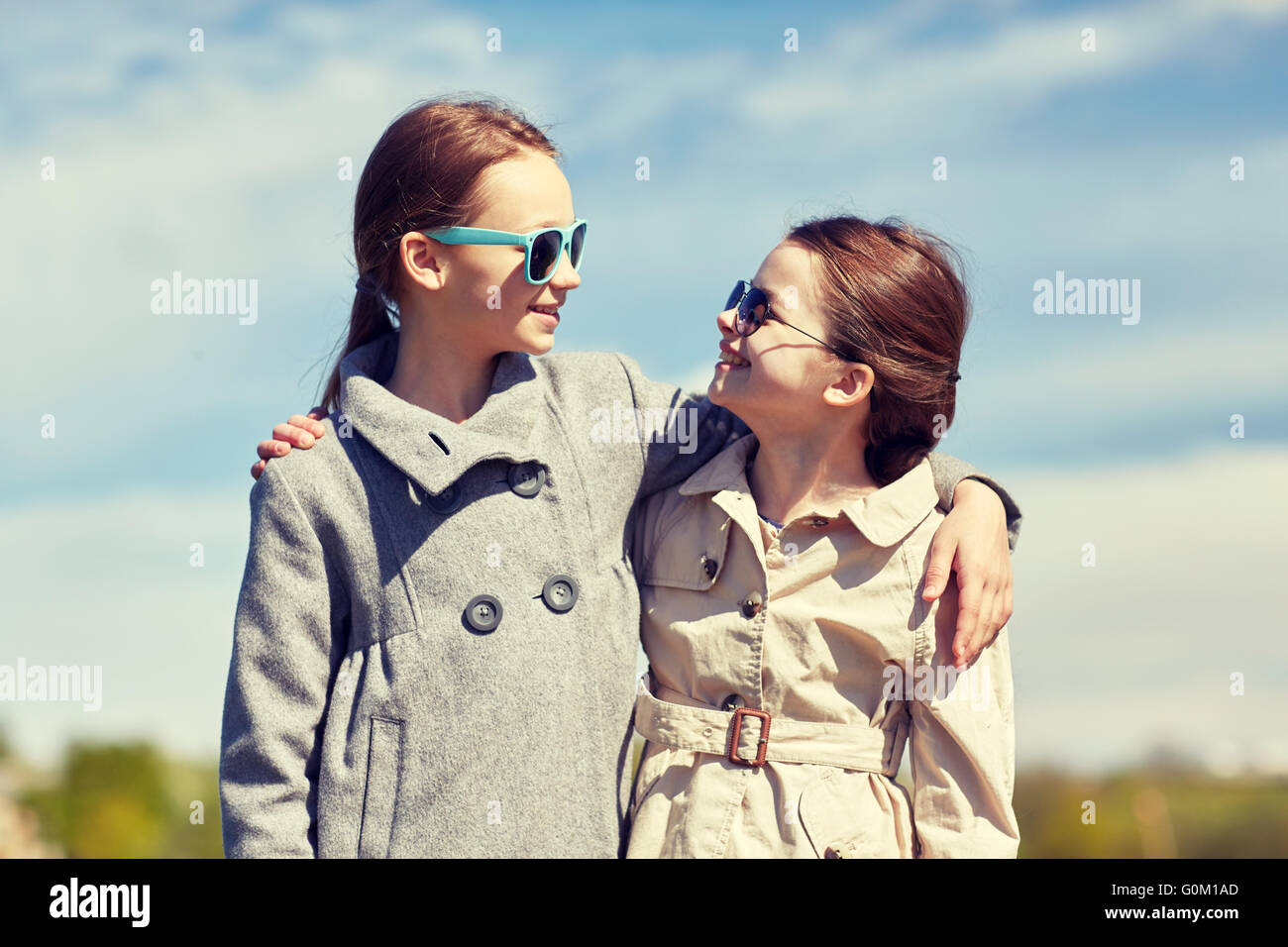 happy little girls hugging and talking outdoors Stock Photo - Alamy