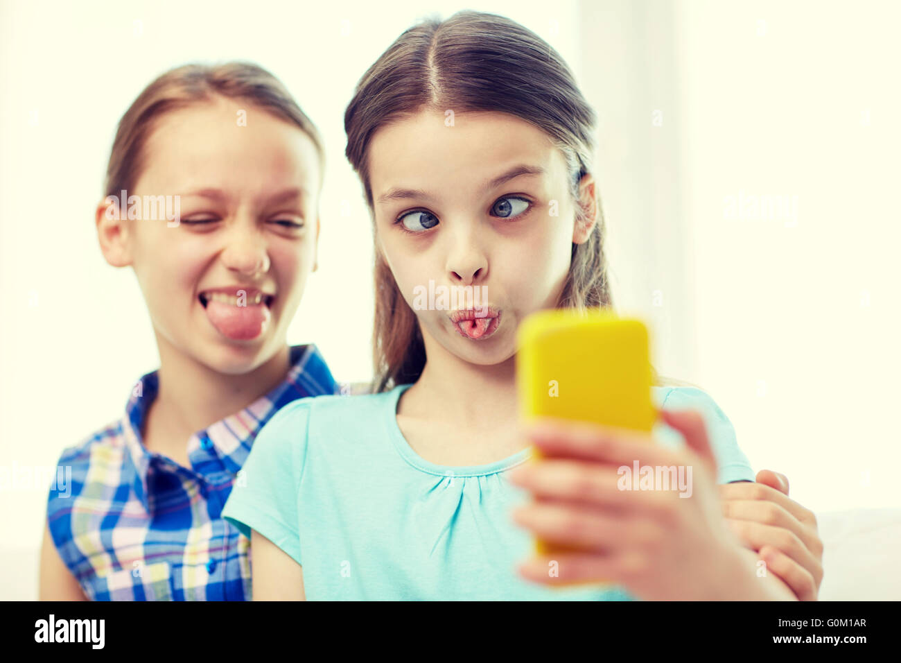 happy girls with smartphone taking selfie at home Stock Photo - Alamy