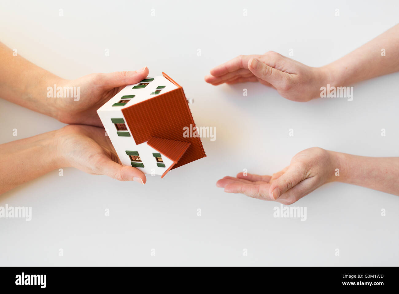 close up of hands giving house or home model Stock Photo