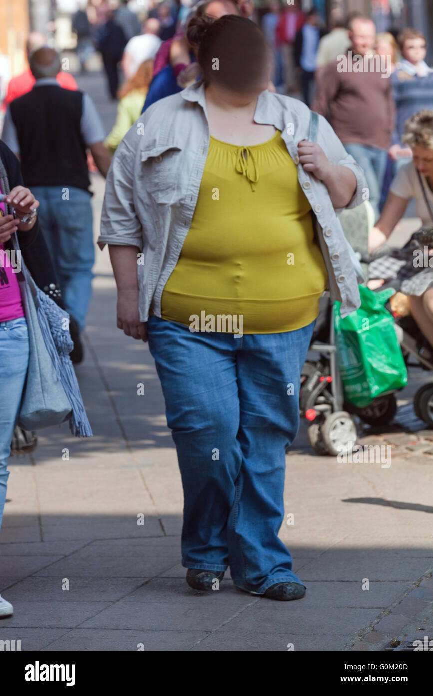 Obese Woman. Walking alone but within a crowd in an urban setting. England. UK. Stock Photo