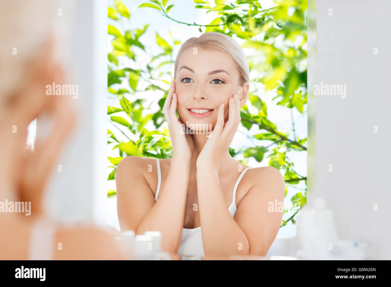 happy young woman looking to mirror at bathroom Stock Photo - Alamy