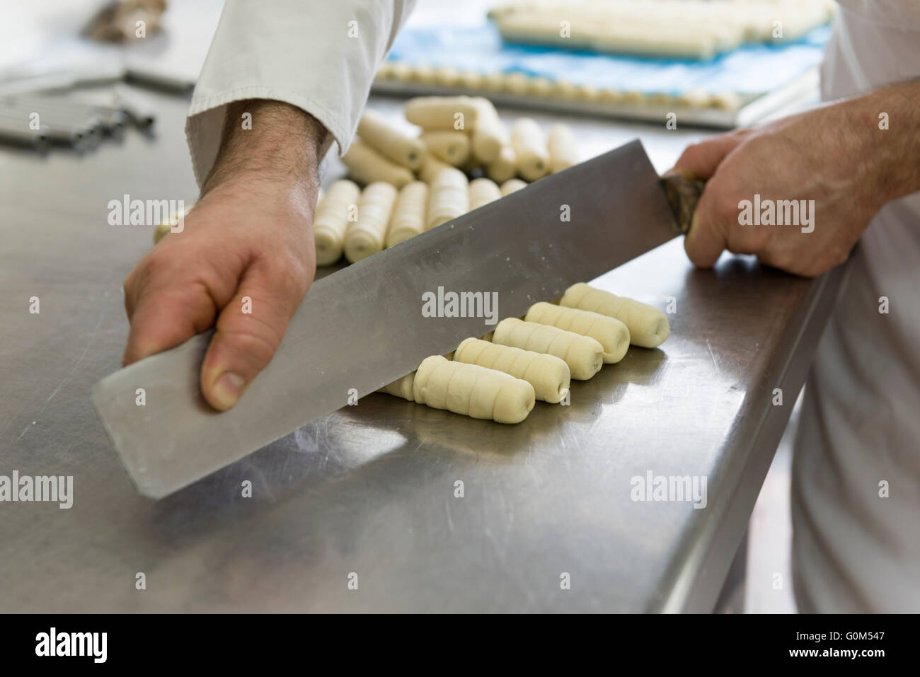 pastry chef cuts the dough for preparing cookies Stock Photo