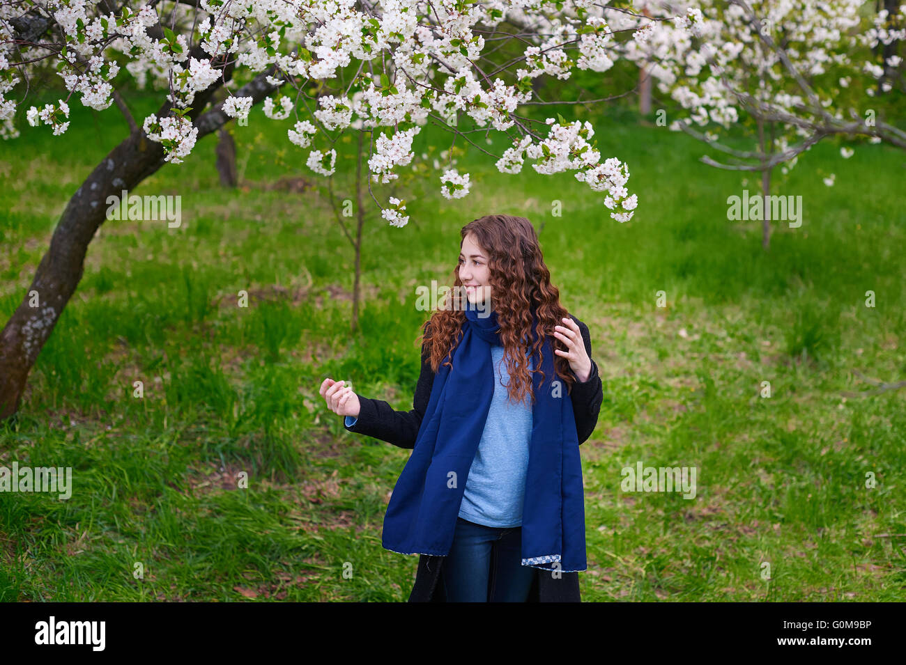 Portrait of young beautiful woman in spring blossom trees Stock Photo