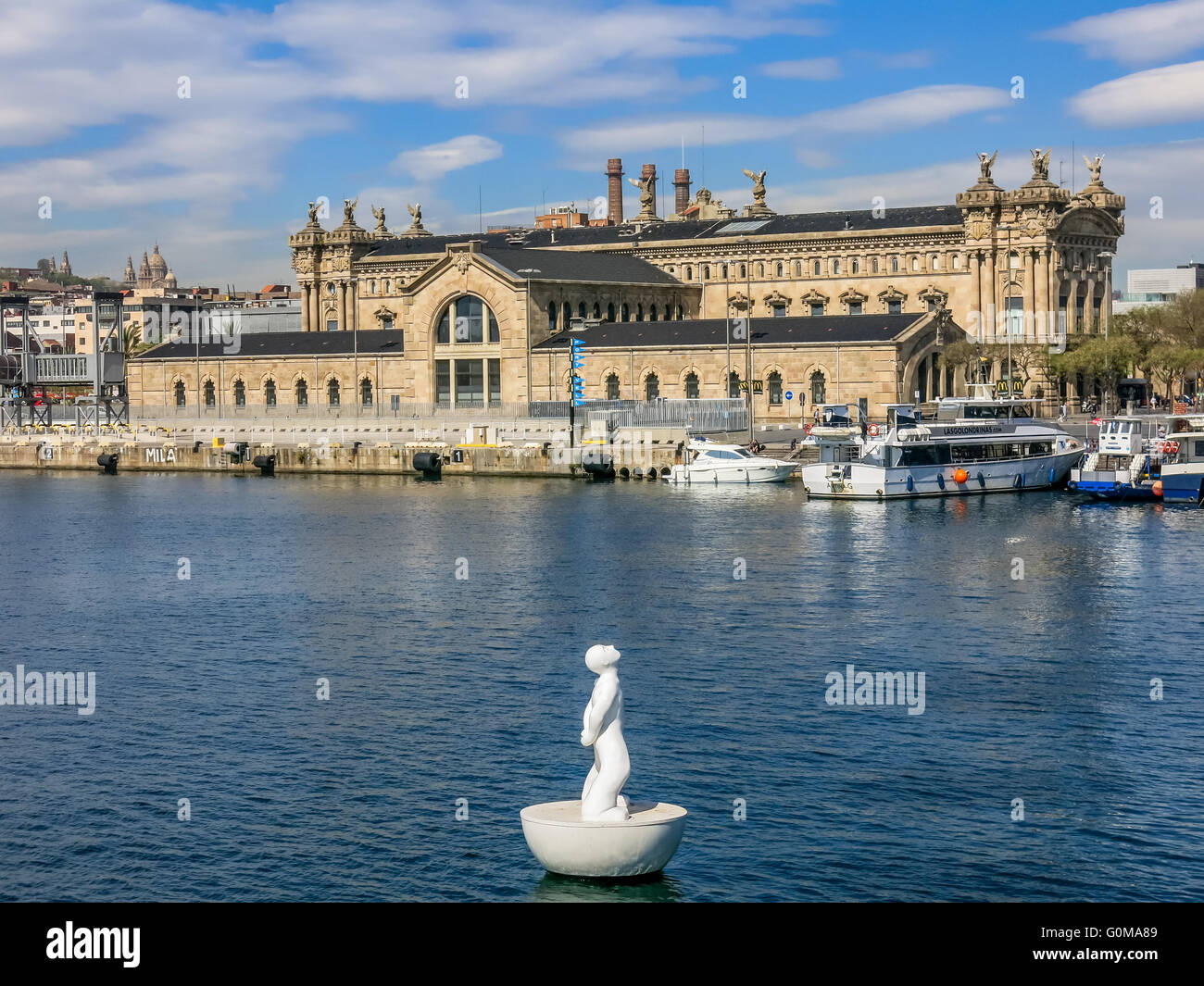 Boy shaped white buoy and Aduana former customs building in Port Vell ...