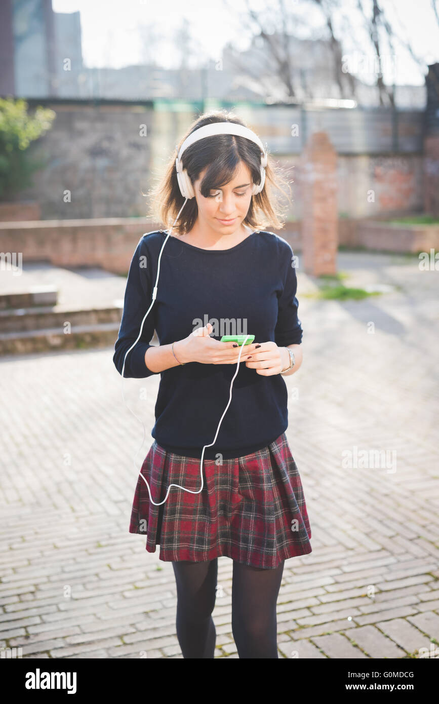 Knee figure of a young pretty brown hair caucasian girl listening music