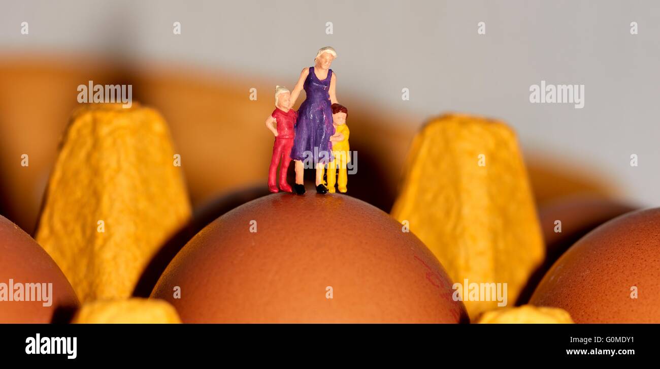 A miniature figurine mother with children standing on an egg Stock Photo