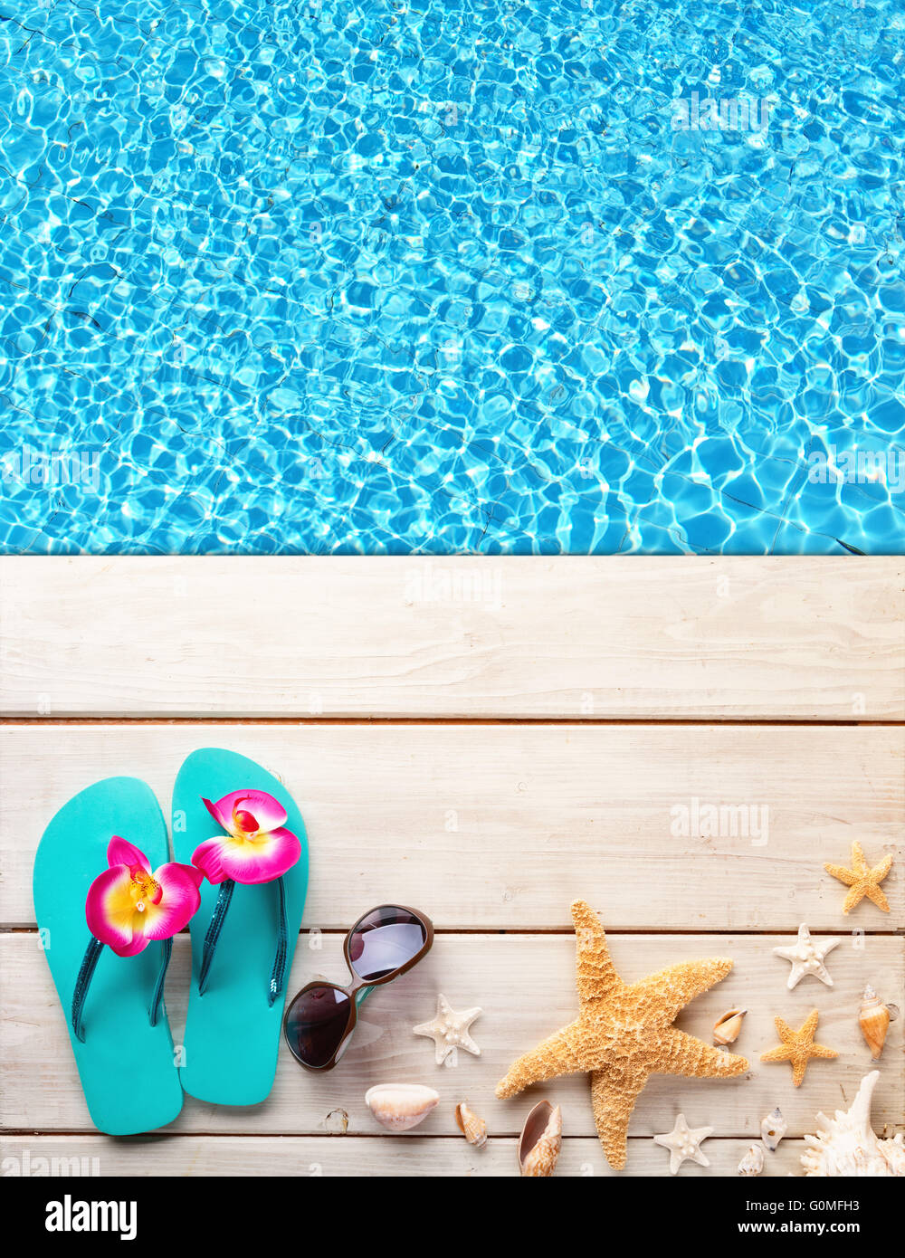 Beach accessories on wooden background placed over swimming pool. Copyspace for text Stock Photo