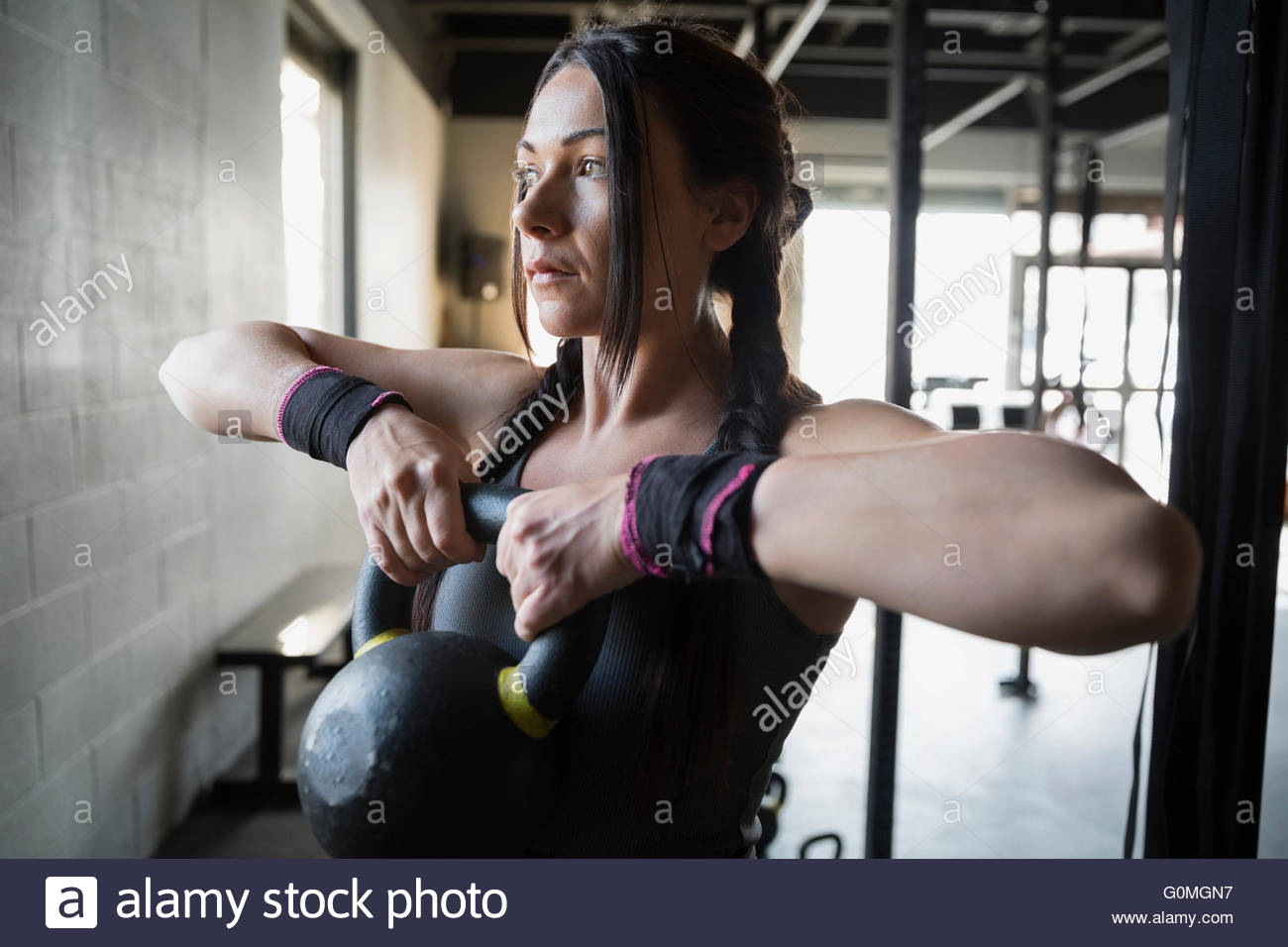 Focused woman weightlifting with kettlebell at gym Stock Photo
