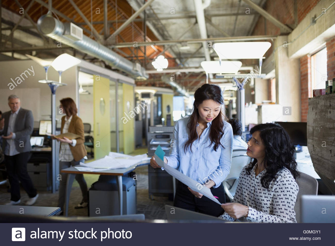 Businesswomen discussing paperwork in office Stock Photo