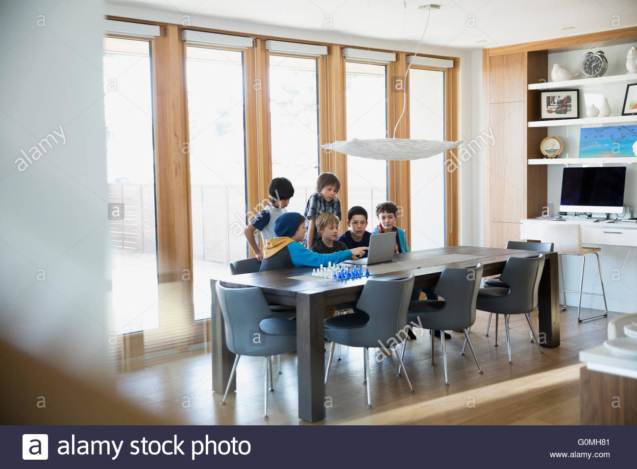 Boys using computer at dining room table Stock Photo - Alamy