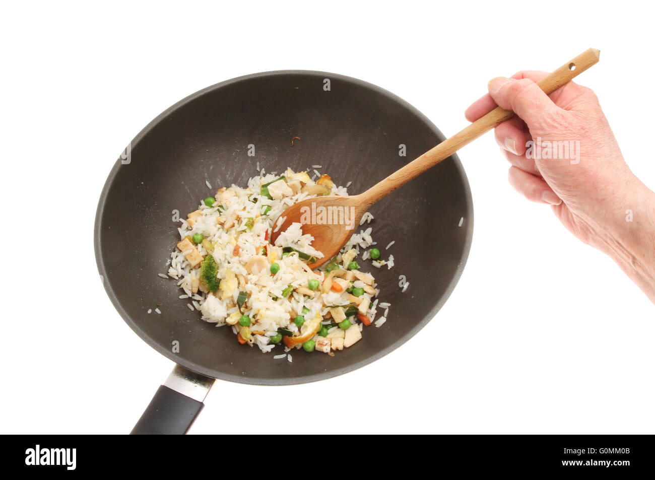 Hand stirring fried rice with a wooden spoon in a wok isolated against white Stock Photo