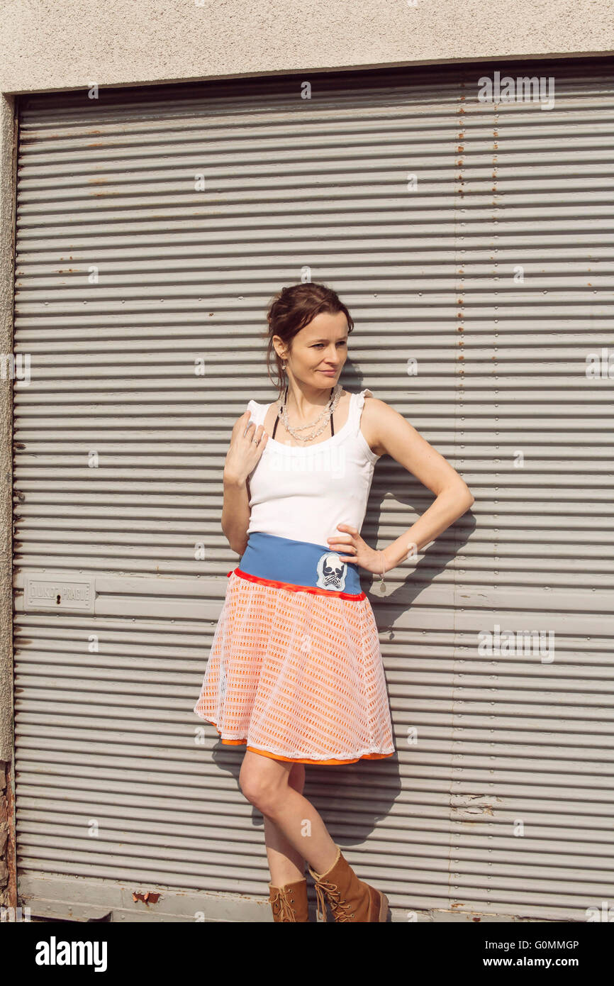Girl standing in front of a metal door Stock Photo - Alamy