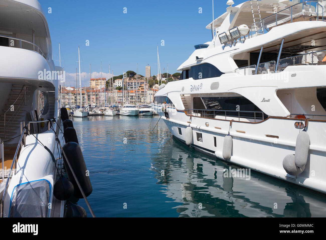 Luxury yachts moored at Cannes, France. The old town of Le Suquet is in the background. Stock Photo