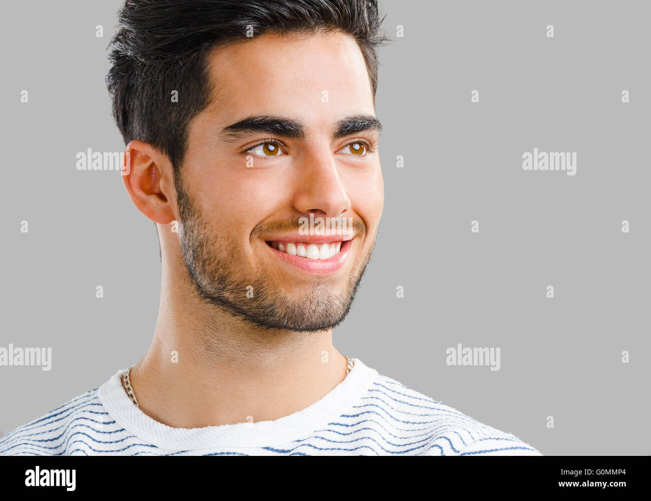 Close-up portrait of handsome young man, isolated over a gray ...