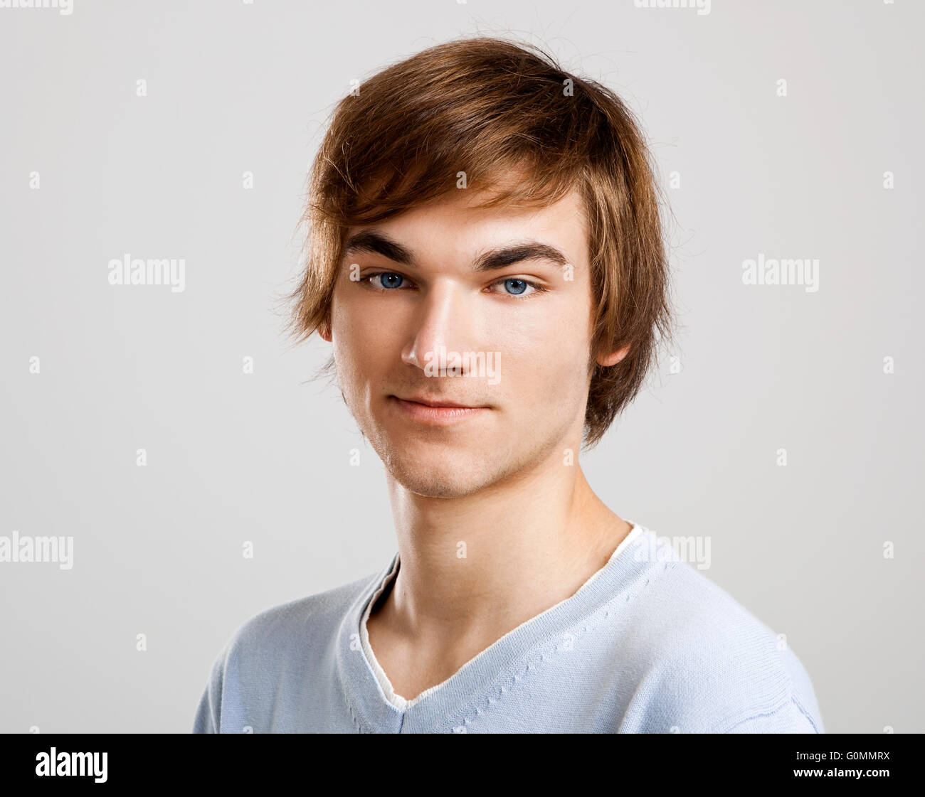 Portrait of a handsome young man over a gray background Stock Photo - Alamy
