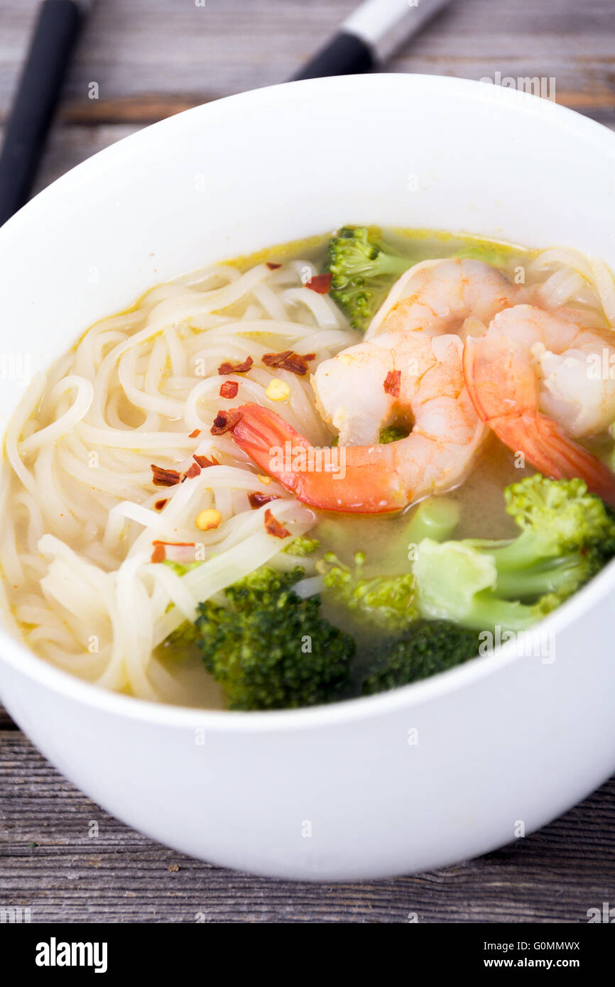 asian prawn rice noodle soup closeup on rustic table Stock Photo
