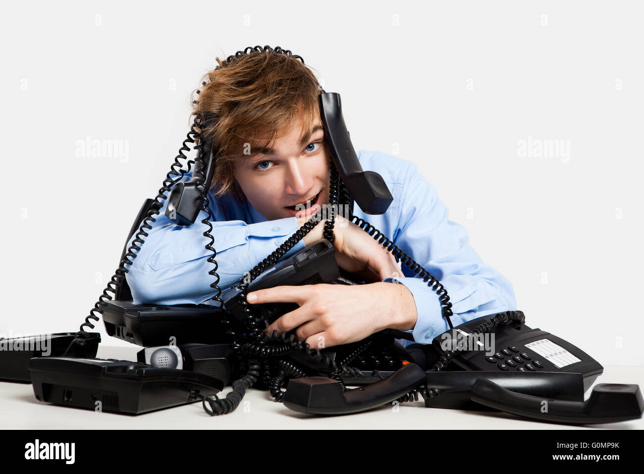 Young man sitting with a bunch of phones over him Stock Photo - Alamy