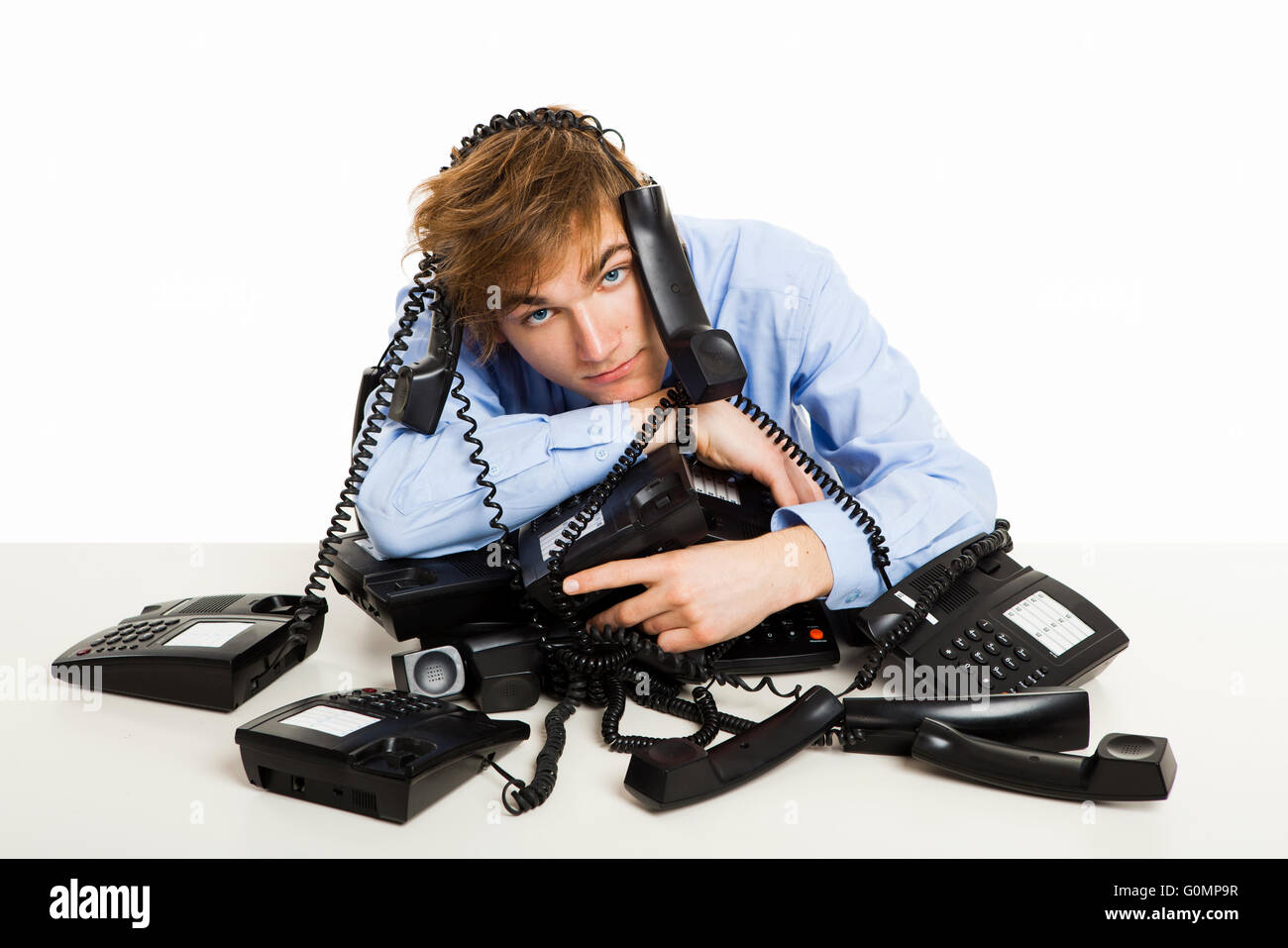 Exhausted man sitting with a bunch of phones over him Stock Photo - Alamy