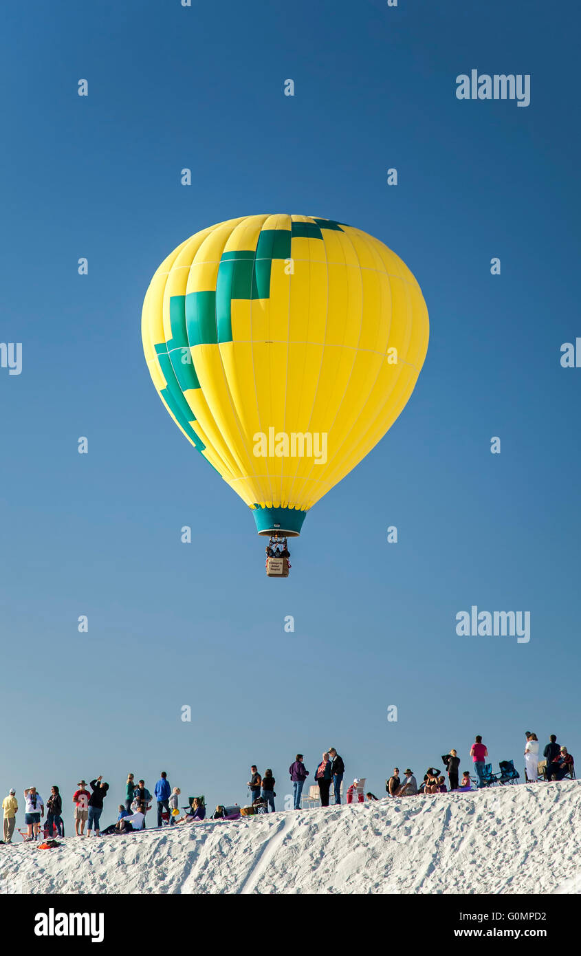 Hot air balloon over crowd and sand dune, White Sands Balloon Festival
