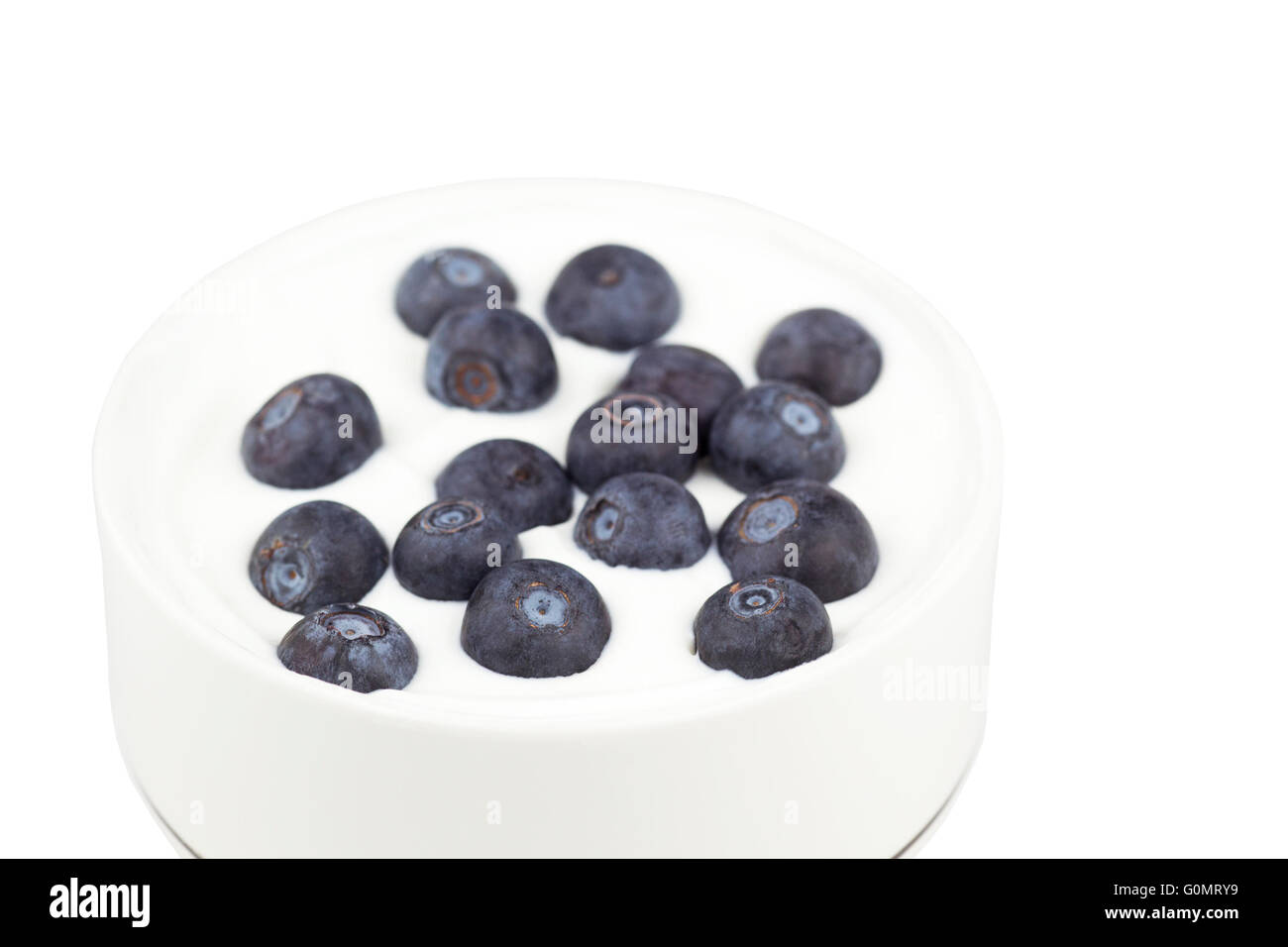 Blueberries sprinkled on bowl of Greek yogurt Stock Photo
