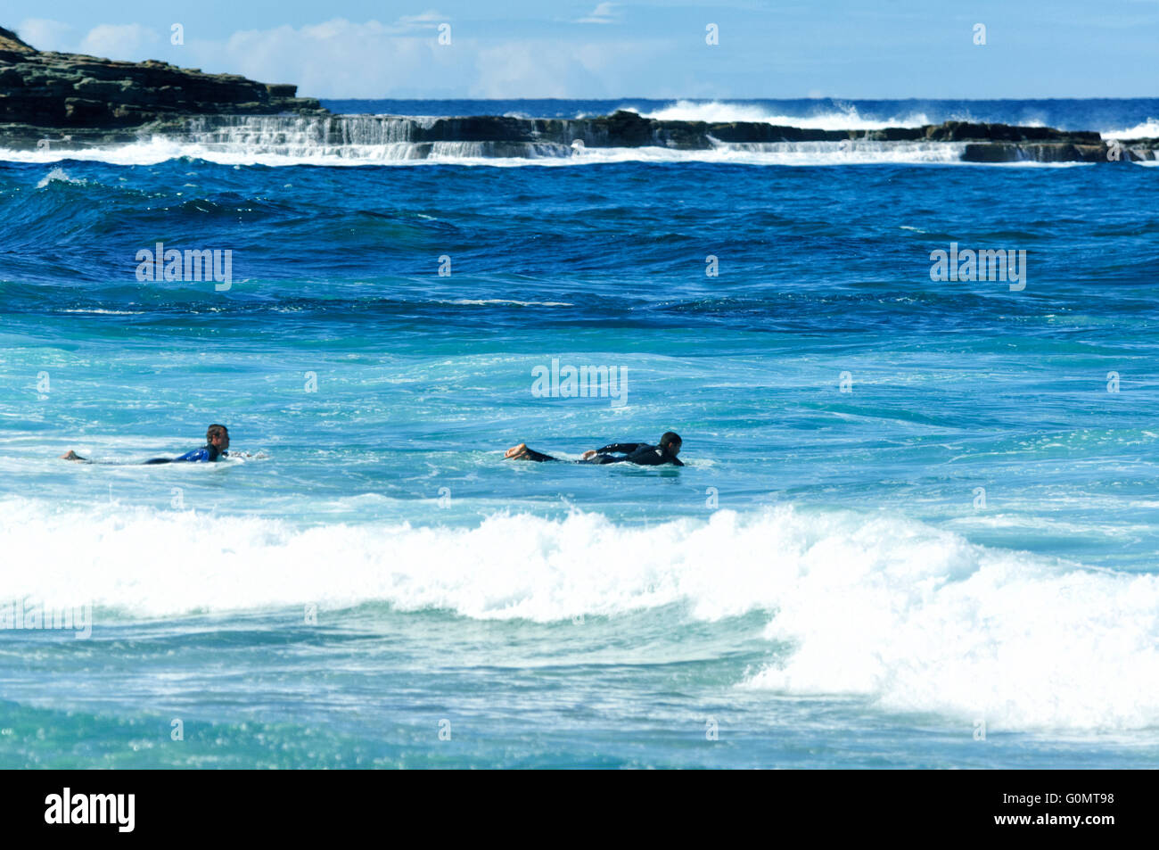 Two Surfers body paddling, Royal National Park, New South Wales, Australia Stock Photo