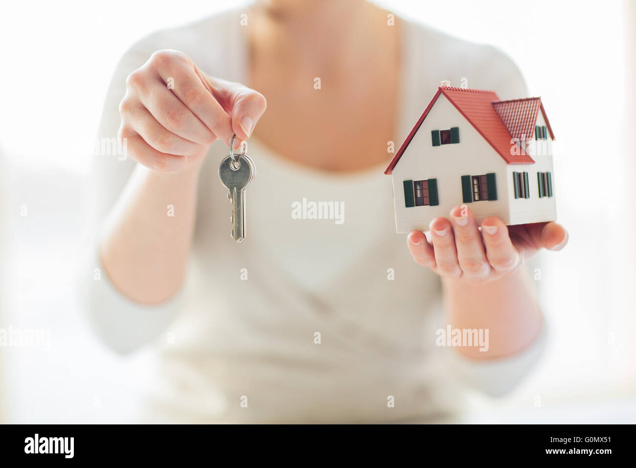 close up of hands holding house model and keys Stock Photo - Alamy