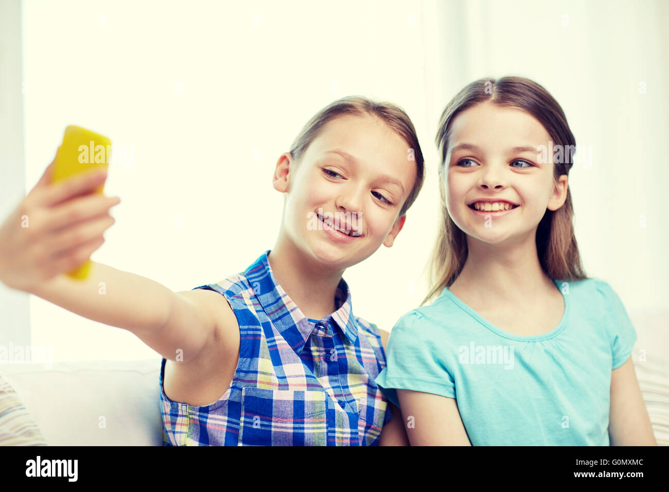 happy girls with smartphone taking selfie at home Stock Photo - Alamy