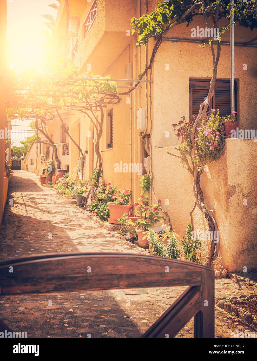 Image of a sunlit village street. Crete, Greece. Vintage styled. Stock Photo